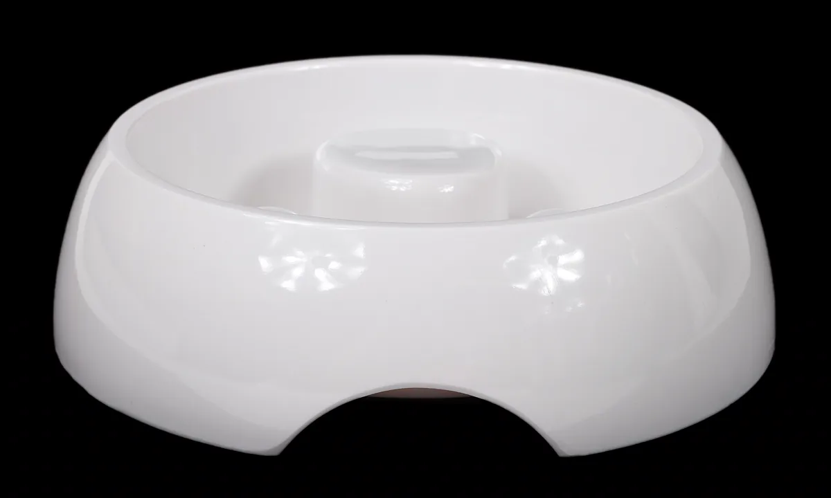 White slow feeder dog bowl with a raised central column, photographed against a black background