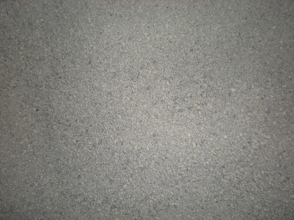 Close-up of fine grey clay cat litter granules filling the frame