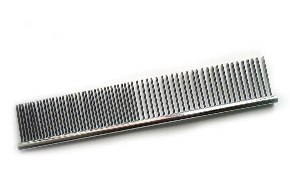 Stainless steel dog grooming comb with long metal teeth, closer together on one half and wider apart on the other