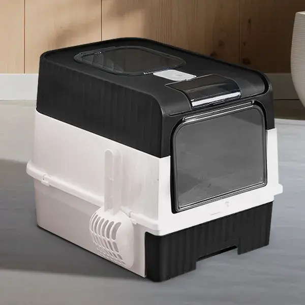 Black and white enclosed cat litter box with clear front door and scoop